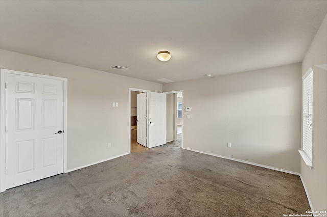 11219 Five Iron, San Antonio, TX 78221 - unfurnished bedroom featuring baseboards, carpet, multiple windows, and ensuite bathroom