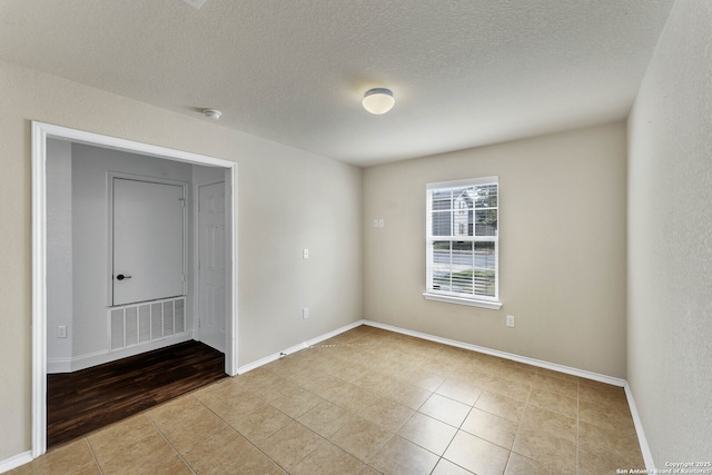 11219 Five Iron, San Antonio, TX 78221 - unfurnished room featuring tile patterned floors, a textured ceiling, and baseboards