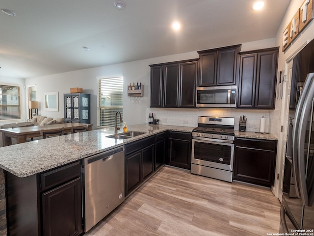4926 Drifter Oaks, Saint Hedwig, TX 78152 - kitchen featuring appliances with stainless steel finishes, a sink, a peninsula, open floor plan, and tasteful backsplash