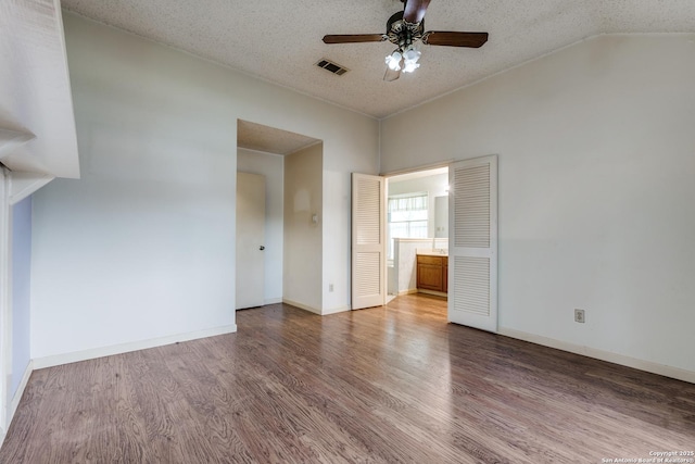 8763 Silent Oaks, San Antonio, TX 78250 - spare room featuring a ceiling fan, wood finished floors, vaulted ceiling, a textured ceiling, and baseboards