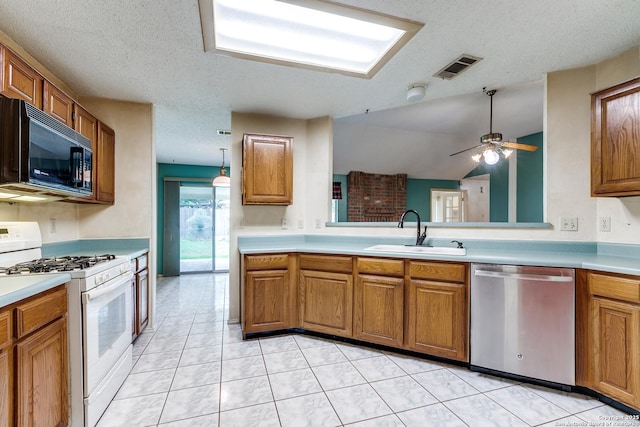 8763 Silent Oaks, San Antonio, TX 78250 - kitchen featuring dishwasher, black microwave, white range with gas stovetop, a sink, and brown cabinets