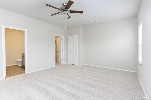 14647 Stirrup Trce, Elmendorf, TX 78112 - unfurnished bedroom with carpet floors, connected bathroom, baseboards, and a ceiling fan