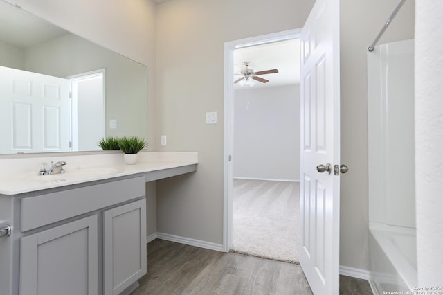 14647 Stirrup Trce, Elmendorf, TX 78112 - full bathroom featuring wood finished floors, vanity, baseboards, and a ceiling fan