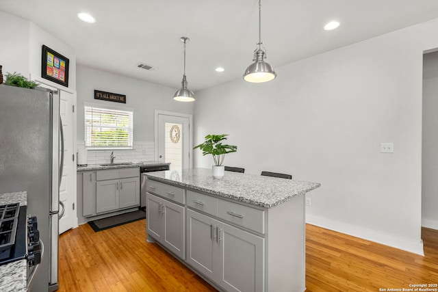 419 Channing Ave, San Antonio, TX 78210 - kitchen with gray cabinets, appliances with stainless steel finishes, light wood-type flooring, a sink, and recessed lighting