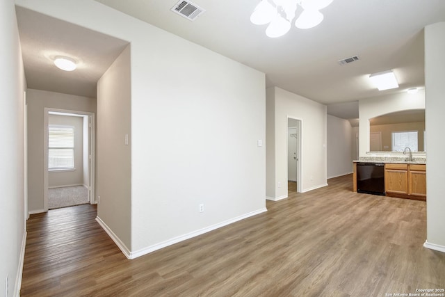 10374 Oakwood Crst, San Antonio, TX 78245 - kitchen featuring dishwasher, light wood-style flooring, arched walkways, a sink, and a chandelier