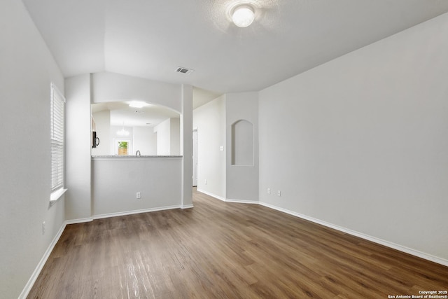 10374 Oakwood Crst, San Antonio, TX 78245 - unfurnished living room featuring wood finished floors, baseboards, and arched walkways