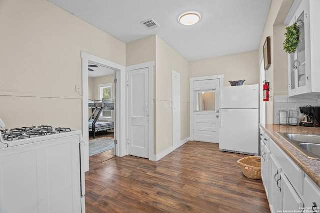 1726 Center, San Antonio, TX 78202 - kitchen featuring white appliances, white cabinets, dark wood-style floors, tasteful backsplash, and a sink