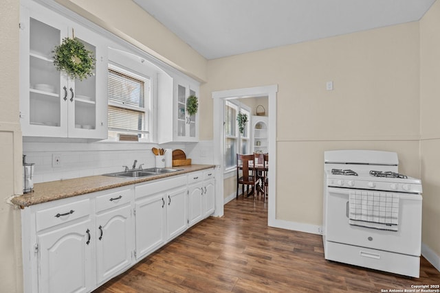 1726 Center, San Antonio, TX 78202 - kitchen featuring white gas range oven, a sink, glass insert cabinets, white cabinetry, and tasteful backsplash
