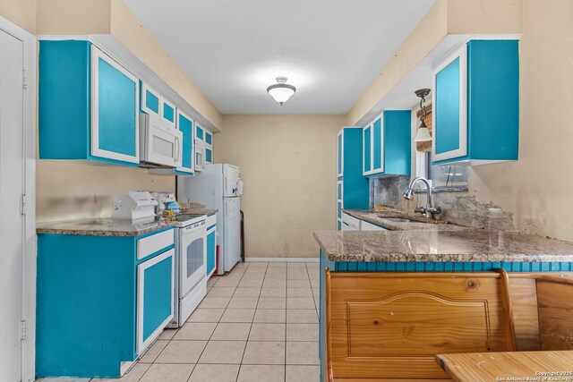 120 Westridge Dr, Springtown, TX 76082 - kitchen with white appliances, a sink, blue cabinets, light tile patterned floors, and glass insert cabinets