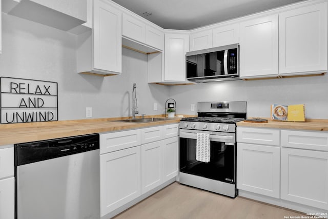 97 Denton, San Antonio, TX 78213 - kitchen featuring stainless steel appliances, a sink, white cabinetry, and wooden counters