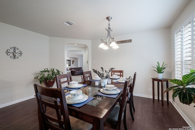 8022 Maddie Ln, San Antonio, TX 78255 - dining area with arched walkways, a chandelier, wood finished floors, and baseboards