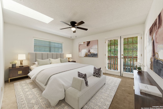 7519 Dijon Ct, San Antonio, TX 78209 - bedroom featuring access to exterior, carpet flooring, a skylight, a textured ceiling, and a ceiling fan