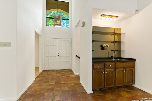 7519 Dijon Ct, San Antonio, TX 78209 - foyer with baseboards, bar with sink, and a high ceiling