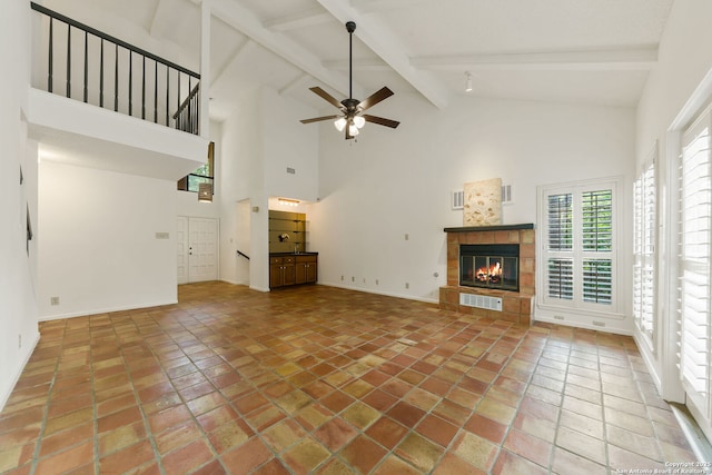 7519 Dijon Ct, San Antonio, TX 78209 - unfurnished living room with a tiled fireplace, plenty of natural light, beam ceiling, a ceiling fan, and high vaulted ceiling