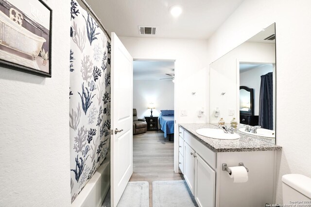 923 Cook Bnd, San Antonio, TX 78221 - ensuite bathroom featuring wood finished floors, vanity, toilet, a ceiling fan, and shower / tub combo with curtain
