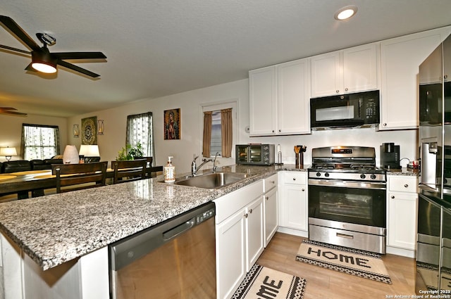 923 Cook Bnd, San Antonio, TX 78221 - kitchen with stainless steel gas stove, black microwave, dishwashing machine, a sink, and ceiling fan