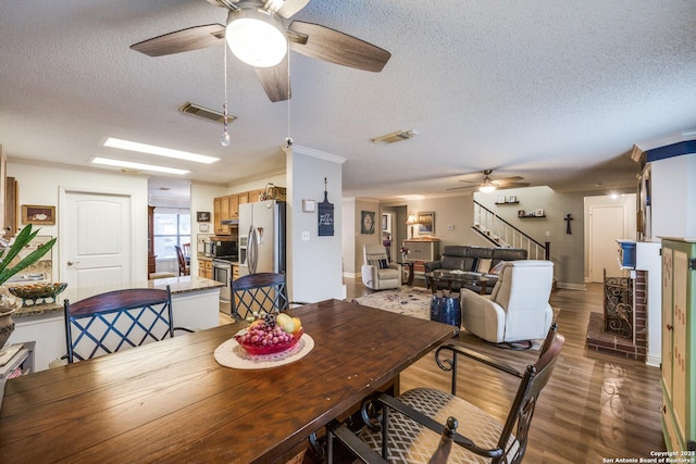 9618 Alderwood, San Antonio, TX 78250 - dining room with a ceiling fan, a textured ceiling, wood finished floors, stairway, and ornamental molding