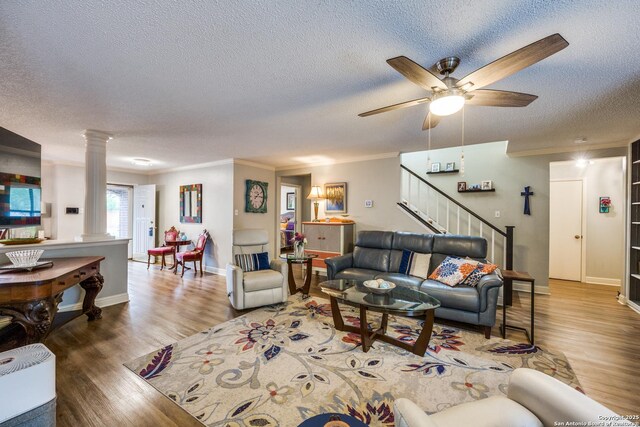 9618 Alderwood, San Antonio, TX 78250 - living room with a textured ceiling, ornate columns, crown molding, stairs, and wood finished floors