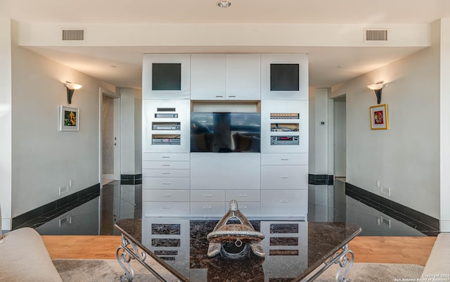 7887 Broadway Unit 1102, San Antonio, TX 78209 - kitchen featuring baseboards, white cabinetry, and dark stone counters