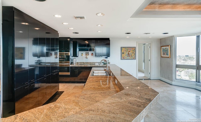 7887 Broadway Unit 1102, San Antonio, TX 78209 - kitchen featuring a sink, modern cabinets, stone countertops, recessed lighting, and baseboards