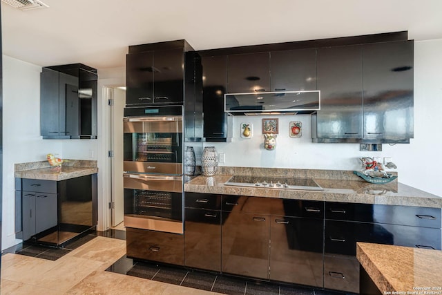 7887 Broadway Unit 1102, San Antonio, TX 78209 - kitchen with under cabinet range hood, tile counters, electric stovetop, and stainless steel double oven