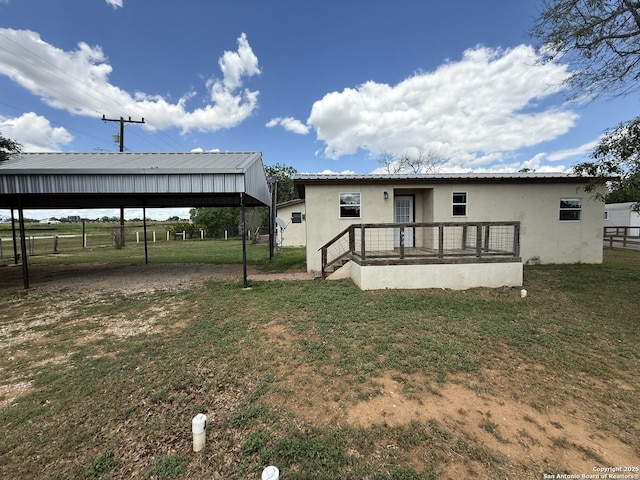 13338 Interstate 35, Moore, TX 78057 - rear view of house with a yard, stucco siding, metal roof, and a carport
