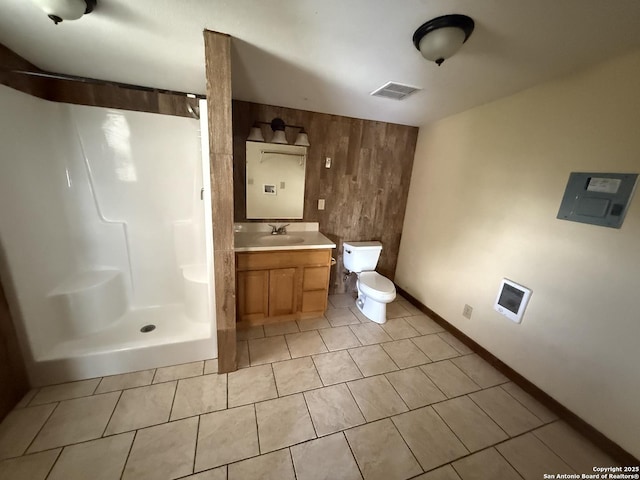 13338 Interstate 35, Moore, TX 78057 - full bathroom featuring walk in shower, vanity, toilet, wood walls, and tile patterned floors