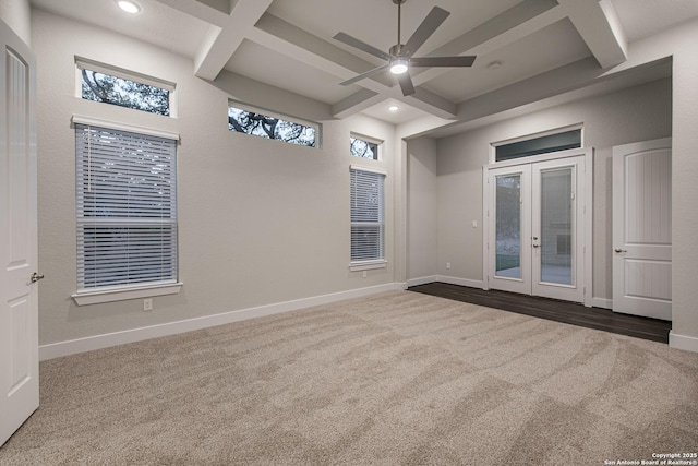 557 Poe Pkwy, Castroville, TX 78009 - spare room featuring coffered ceiling, dark colored carpet, a ceiling fan, beam ceiling, and french doors