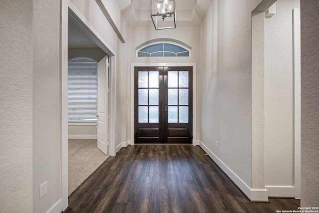 557 Poe Pkwy, Castroville, TX 78009 - foyer entrance featuring a textured wall, baseboards, dark wood-style flooring, a chandelier, and french doors