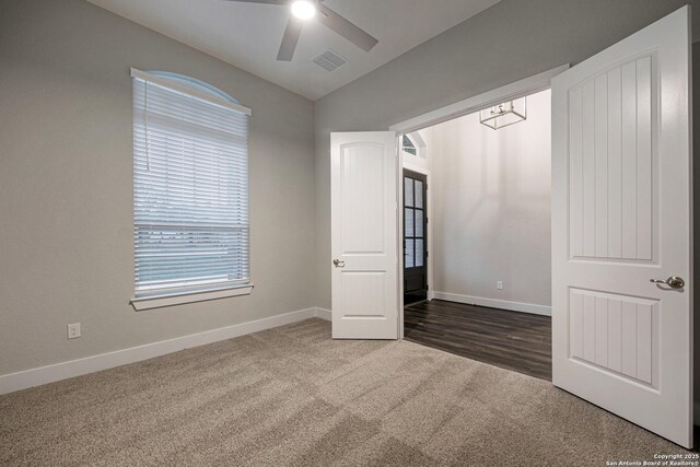 557 Poe Pkwy, Castroville, TX 78009 - spare room featuring vaulted ceiling, carpet floors, baseboards, and a ceiling fan