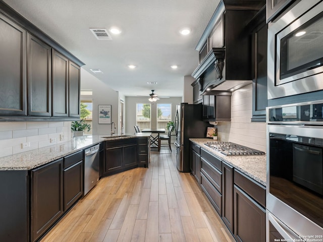 126 Stout Cv, Cibolo, TX 78108 - kitchen with appliances with stainless steel finishes, a sink, a ceiling fan, light stone countertops, and recessed lighting