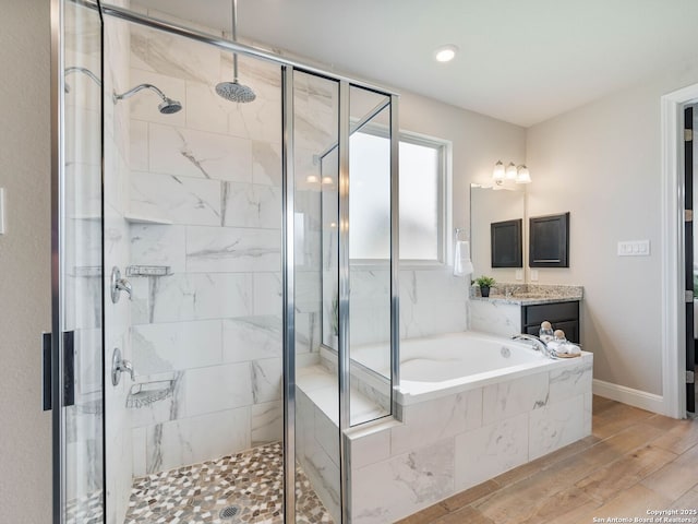 126 Stout Cv, Cibolo, TX 78108 - full bathroom featuring a stall shower, a garden tub, vanity, wood finished floors, and baseboards