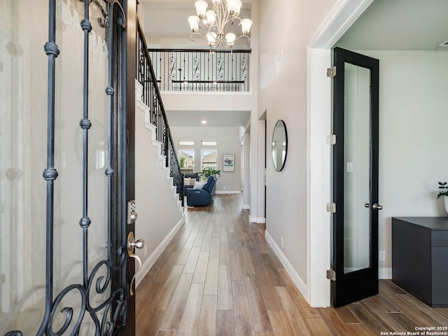 126 Stout Cv, Cibolo, TX 78108 - foyer featuring wood finished floors, stairway, a chandelier, and baseboards
