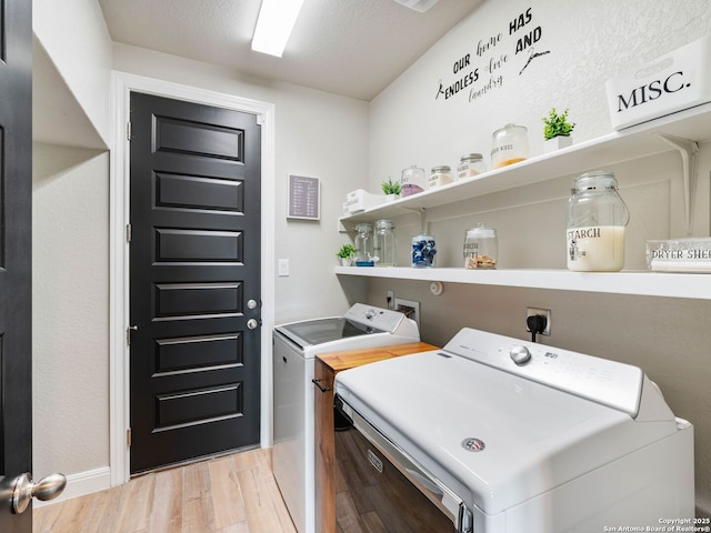 126 Stout Cv, Cibolo, TX 78108 - laundry area featuring washing machine and dryer, light wood-style flooring, and baseboards