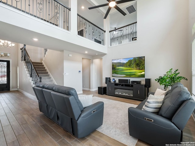 126 Stout Cv, Cibolo, TX 78108 - living room featuring baseboards, wood finished floors, a chandelier, stairway, and a high ceiling