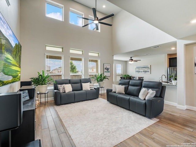 126 Stout Cv, Cibolo, TX 78108 - living room featuring ceiling fan, light wood-type flooring, healthy amount of natural light, a towering ceiling, and recessed lighting
