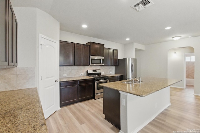 15206 Field Sparrow, San Antonio, TX 78253 - kitchen with appliances with stainless steel finishes, arched walkways, a sink, light wood-style floors, and recessed lighting