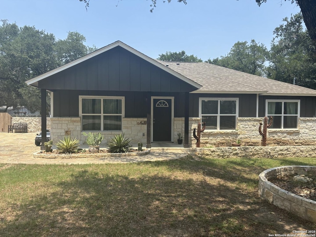 1349 Covered Wagon, Spring Branch, TX 78070 - view of front facade with roof with shingles, stone siding, board and batten siding, and a front lawn