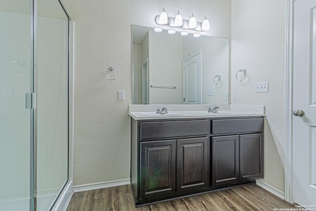 2733 Barkey Spg, San Antonio, TX 78245 - full bathroom with wood finished floors, a textured wall, a stall shower, and baseboards