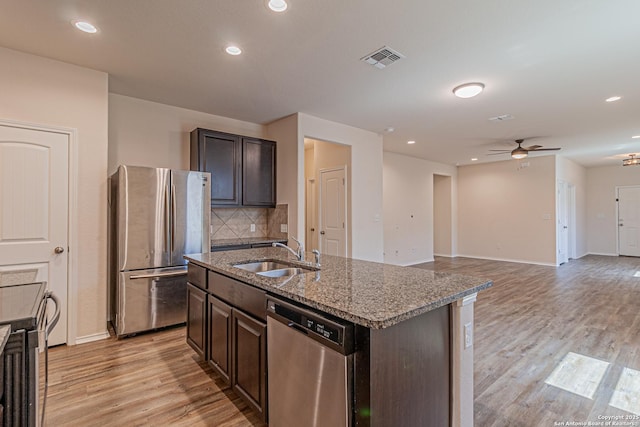 2733 Barkey Spg, San Antonio, TX 78245 - kitchen with stainless steel appliances, a sink, a ceiling fan, light wood finished floors, and a kitchen island with sink