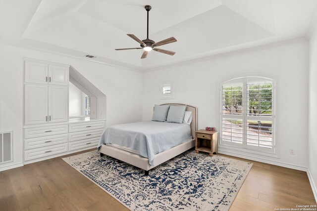 113 Carino Cv, Boerne, TX 78006 - bedroom featuring a tray ceiling, wood finished floors, a ceiling fan, and crown molding