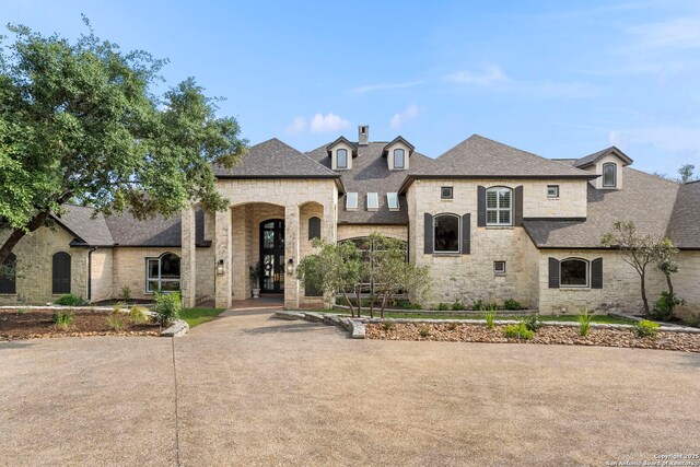 113 Carino Cv, Boerne, TX 78006 - french country home featuring stone siding, roof with shingles, and a chimney