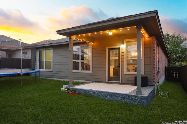 12234 Redbud Leaf, San Antonio, TX 78253 - back of house at dusk featuring a trampoline, a patio, and cooling unit
