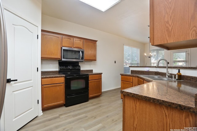 12234 Redbud Leaf, San Antonio, TX 78253 - kitchen with black / electric stove, stainless steel microwave, a sink, dark countertops, and light wood-style flooring