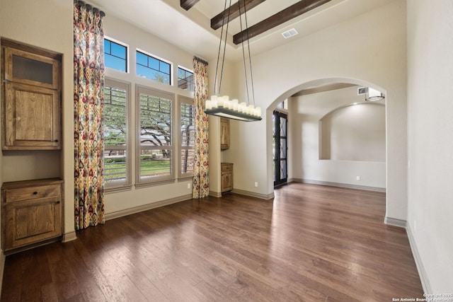 1078 Star Rdg, Spring Branch, TX 78070 - unfurnished dining area featuring arched walkways, a towering ceiling, dark wood-type flooring, baseboards, and a chandelier
