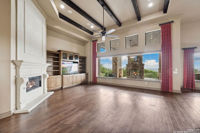 1078 Star Rdg, Spring Branch, TX 78070 - unfurnished living room with a high end fireplace, ceiling fan, beamed ceiling, plenty of natural light, and dark wood-style floors
