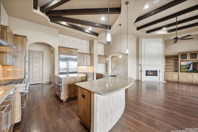 1078 Star Rdg, Spring Branch, TX 78070 - kitchen with a spacious island, arched walkways, stainless steel built in refrigerator, a sink, and brown cabinetry