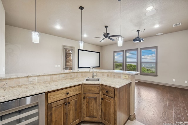 1078 Star Rdg, Spring Branch, TX 78070 - kitchen with beverage cooler, a sink, light stone counters, brown cabinets, and recessed lighting