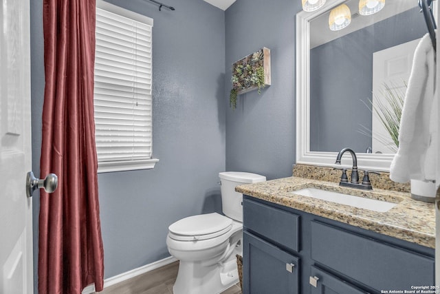 7715 Beechnut Oak, San Antonio, TX 78223 - bathroom featuring toilet, vanity, wood finished floors, and baseboards