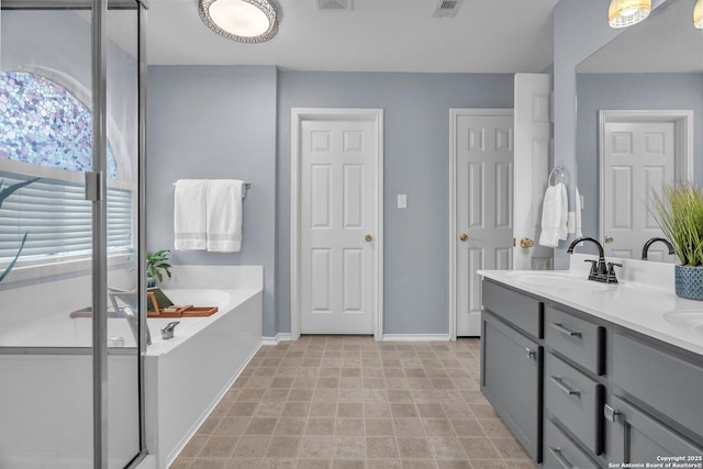 7715 Beechnut Oak, San Antonio, TX 78223 - bathroom with double vanity, baseboards, and a bath
